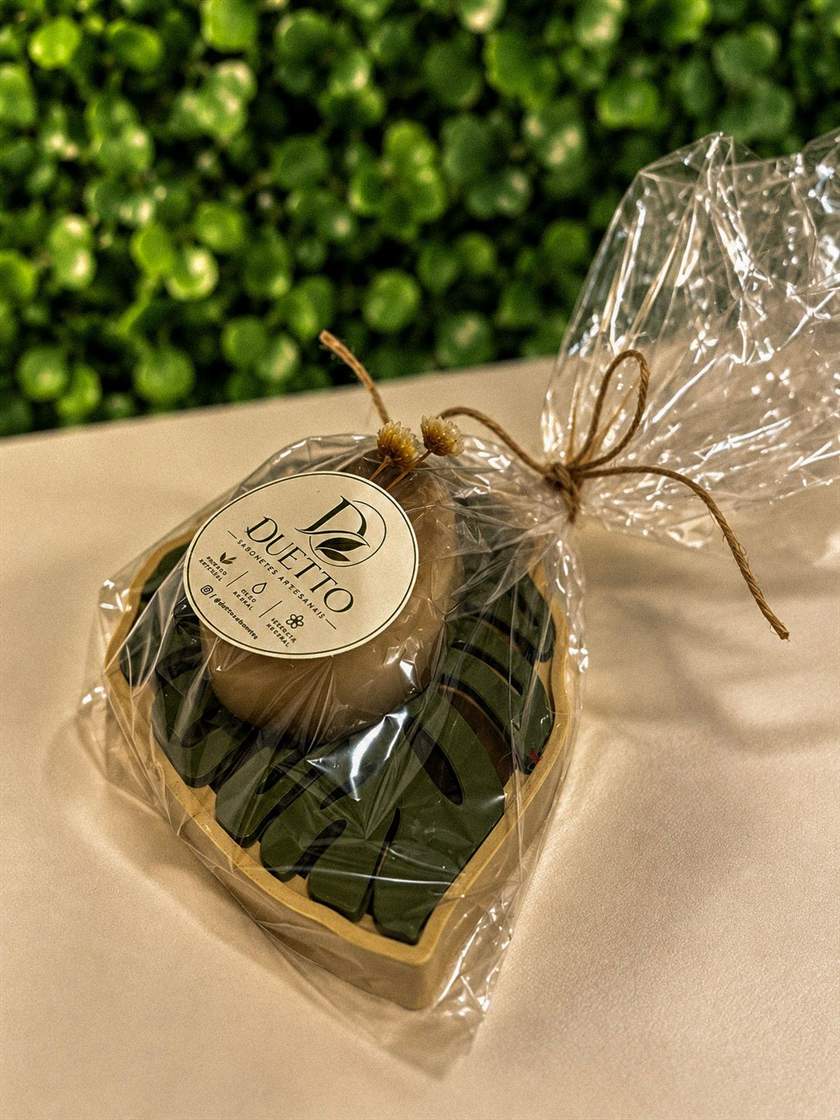 Kit com sabonete massageador amarelo e saboneteira rosa, embalados em celofane com flores secas e etiqueta Duetto (foto 3 de 6)